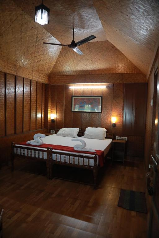 a bedroom with a large bed with a ceiling fan at Sajeev Home Stay in Cherai Beach