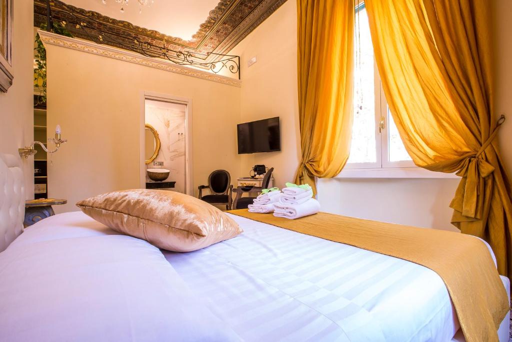 una camera da letto con un grande letto con tende gialle di Trastevere Royal Suite Trilussa a Roma