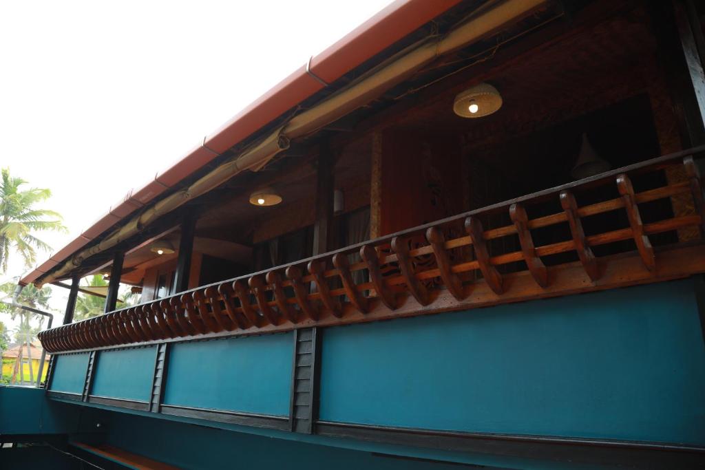 a building with a balcony on top of it at Sajeev Home Stay in Cherai Beach