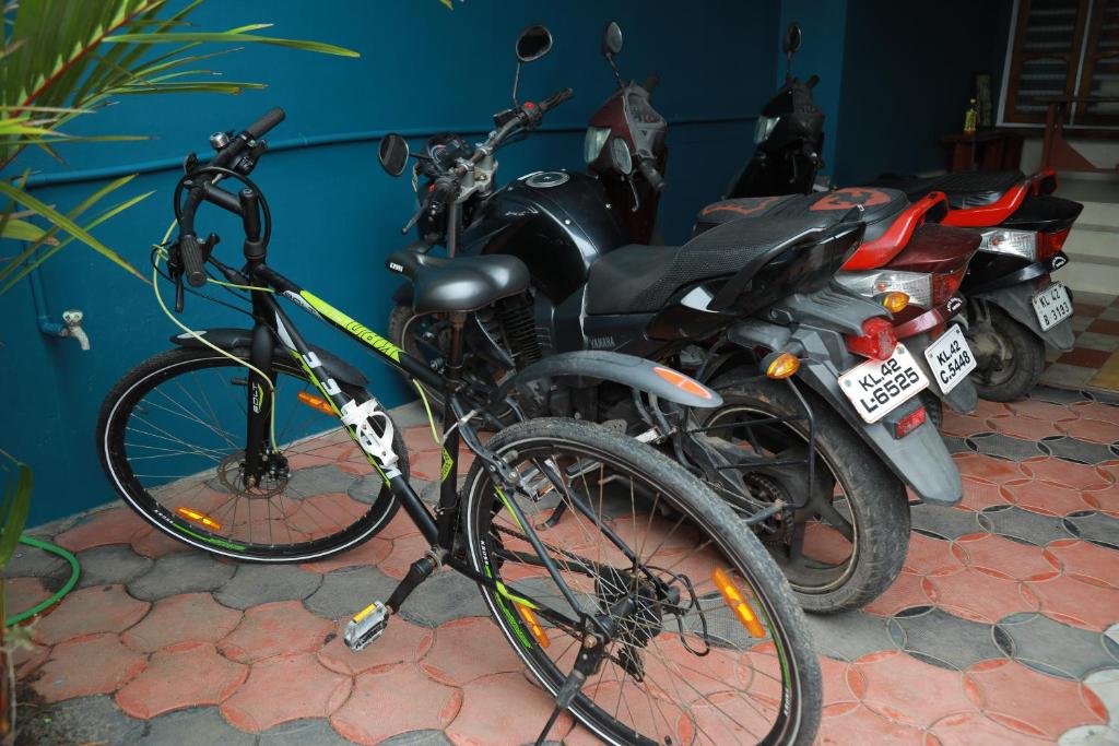 a bicycle is parked next to a group of motorcycles at Sajeev Home Stay in Cherai Beach