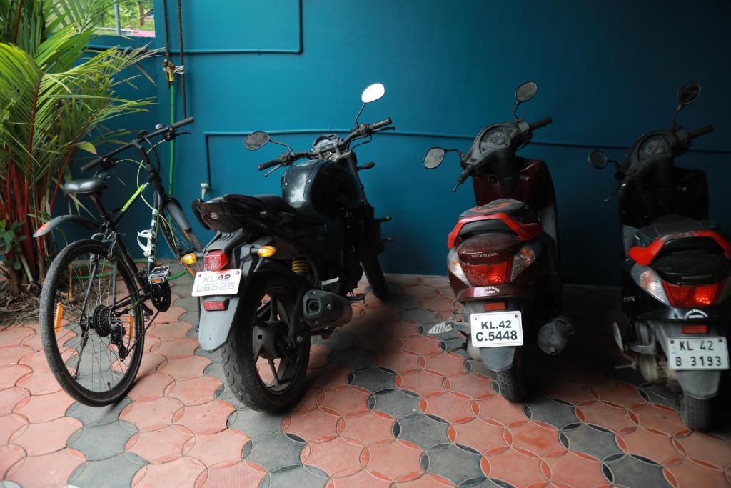 a group of motorcycles parked next to a wall at Sajeev Home Stay in Cherai Beach
