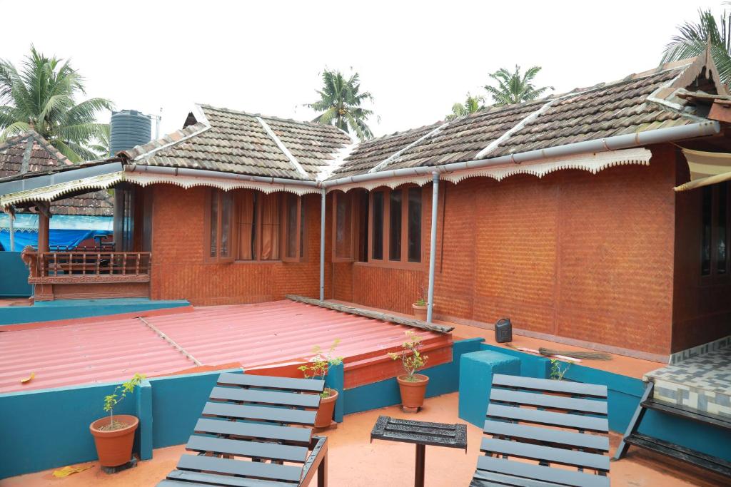 a patio with two chairs and a house at Sajeev Home Stay in Cherai Beach