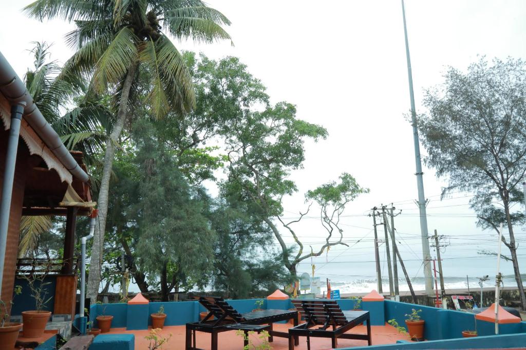 a row of benches sitting next to the beach at Sajeev Home Stay in Cherai Beach
