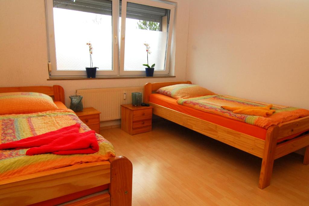 a bedroom with two beds and a window at Monteurwohnungen Krings Am Steinbüchel 1 in Eschweiler