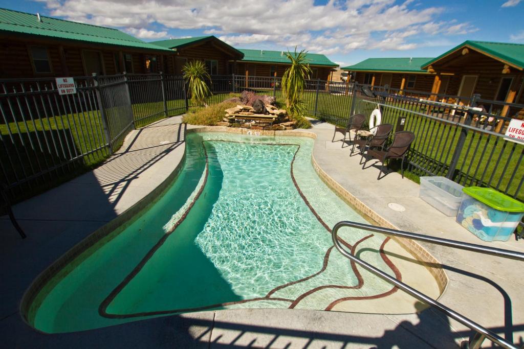 uma piscina num quintal ao lado de uma casa em Cody Cowboy Village em Cody
