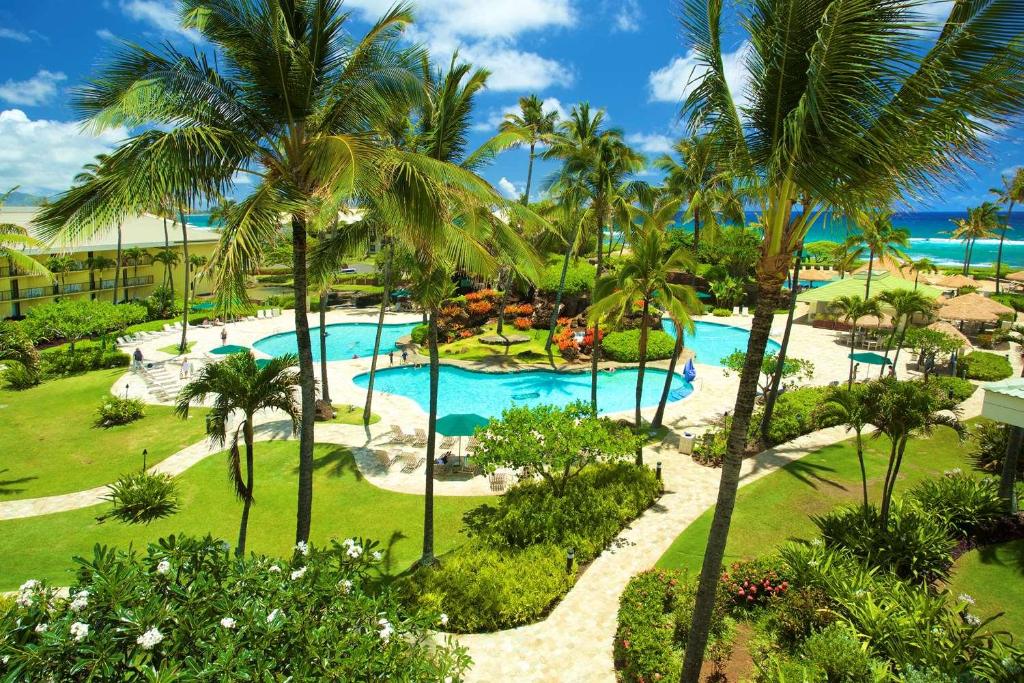 an aerial view of a resort pool with palm trees at Kauai Beach Resort & Spa in Lihue