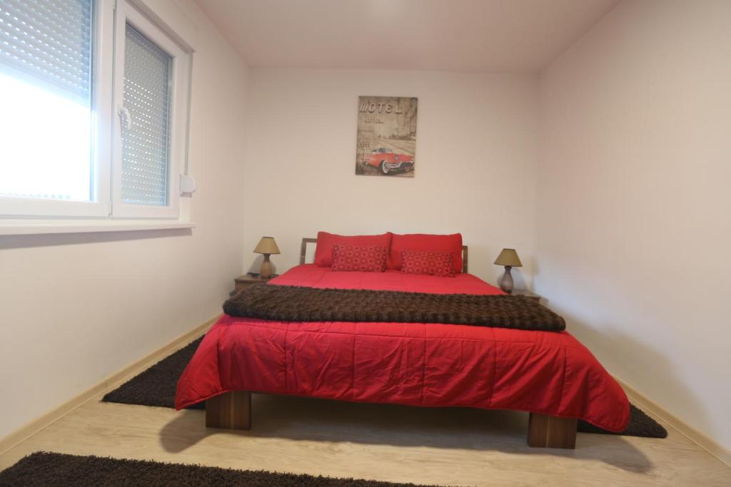 a bedroom with a red bed with red pillows at Seher in Sarajevo