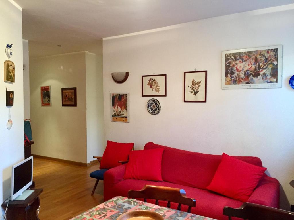 a living room with a red couch and some pictures on the wall at Elegante appartamento in centro a bardonecchia in Bardonecchia