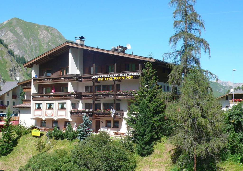 ein großes Gebäude auf einem Hügel mit Bäumen in der Unterkunft Apartment Bergsonne in Samnaun