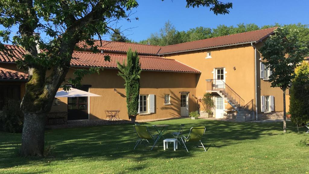 a house with a table and chairs in the yard at B&B La Cerisaie in Francheleins