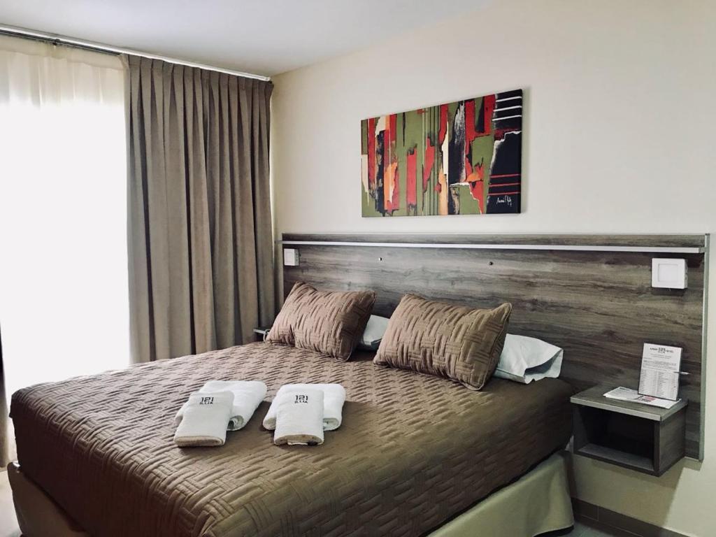 um quarto com uma cama com duas toalhas em ILLIA 121 APART HOTEL em Neuquén