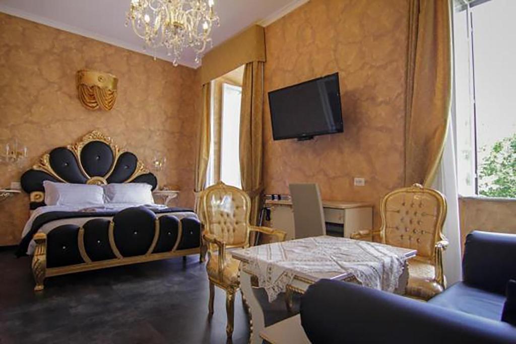 - une chambre avec un lit et une télévision murale dans l'établissement Pope's Suites, à Rome