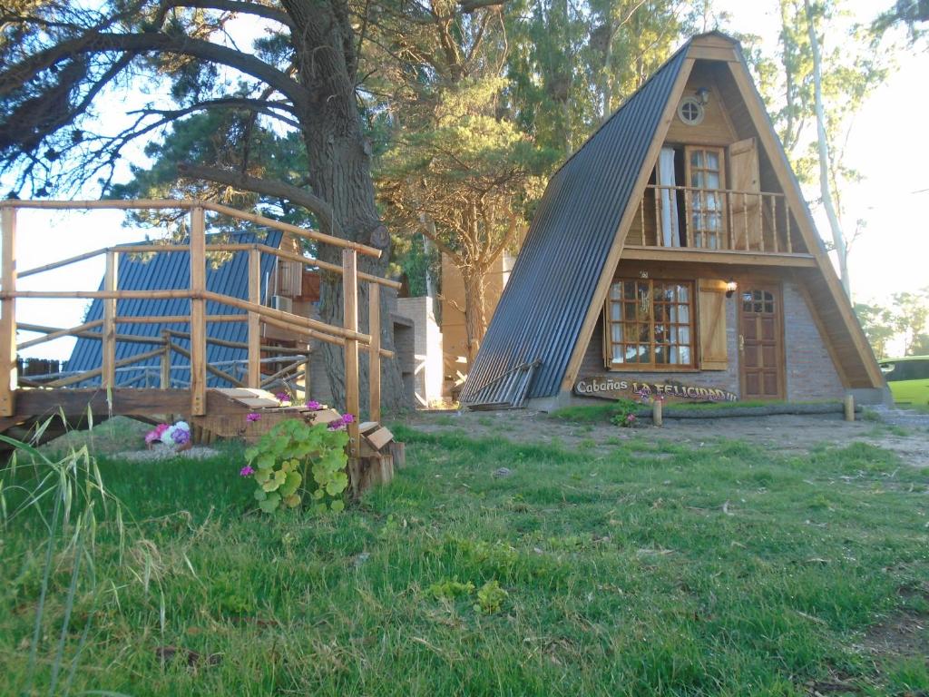 una pequeña casa con techo de gambrel en un patio en La Felicidad en Balneario Claromecó