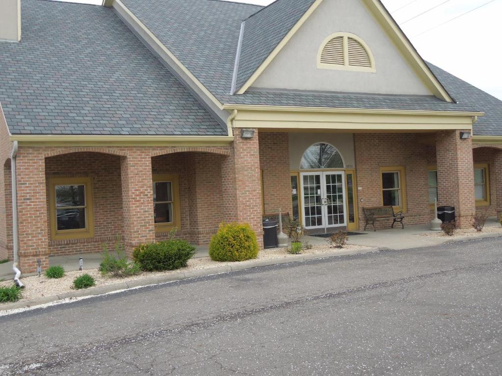 a brick house with a porch and a driveway at Quality Inn & Suites Dublin in Dublin