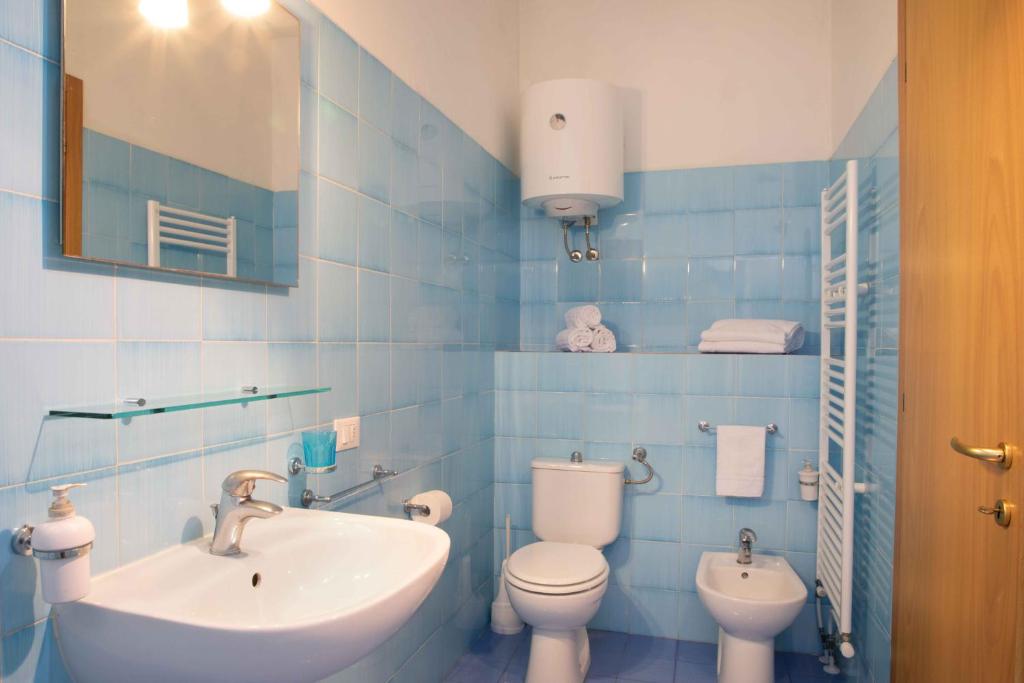 W wyłożonej niebieskimi kafelkami łazience znajduje się umywalka i toaleta. w obiekcie Al Frantoio Maddii Levane bed and breakfast w mieście Levane