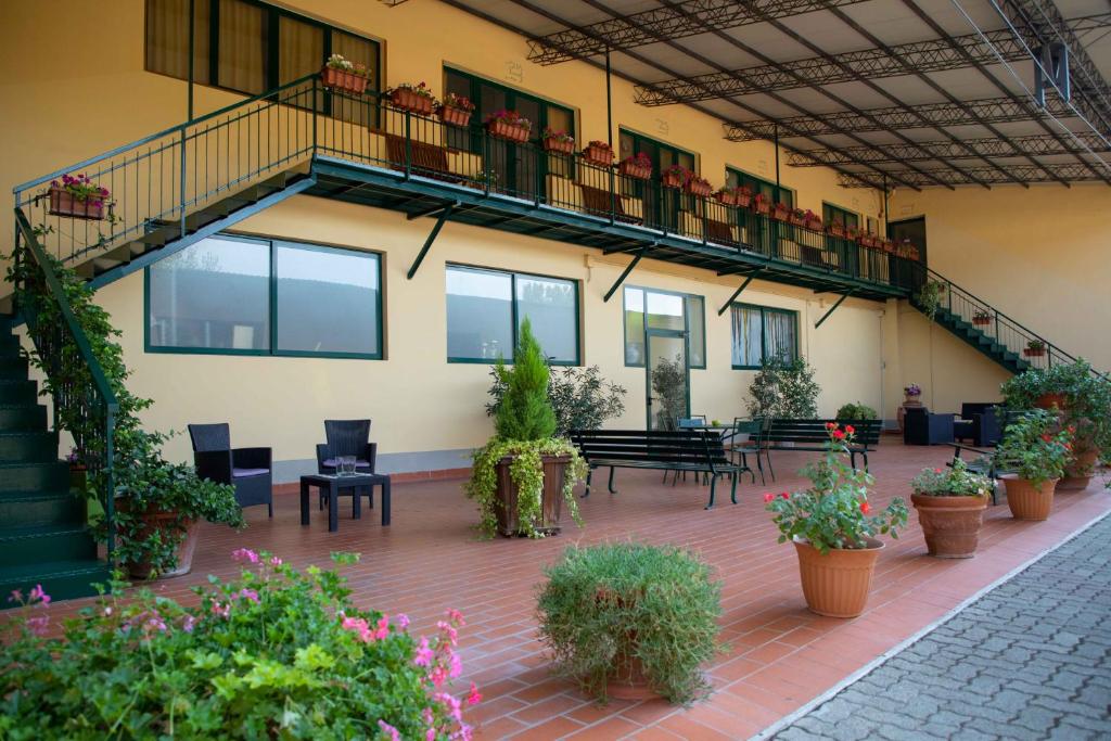 une cour avec des tables, des chaises et des plantes dans l'établissement Al Frantoio Maddii Levane bed and breakfast, à Levane