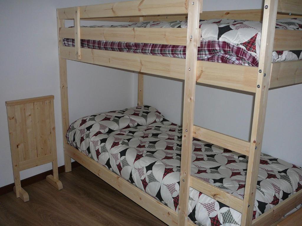 a bunk bed with a wooden bunk bed frame at Casa Screm - Appartamenti e Camere in Rigolato
