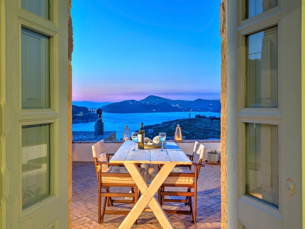 a table on a patio with a view of the ocean at Eirini Luxury Hotel Villas in Grikos