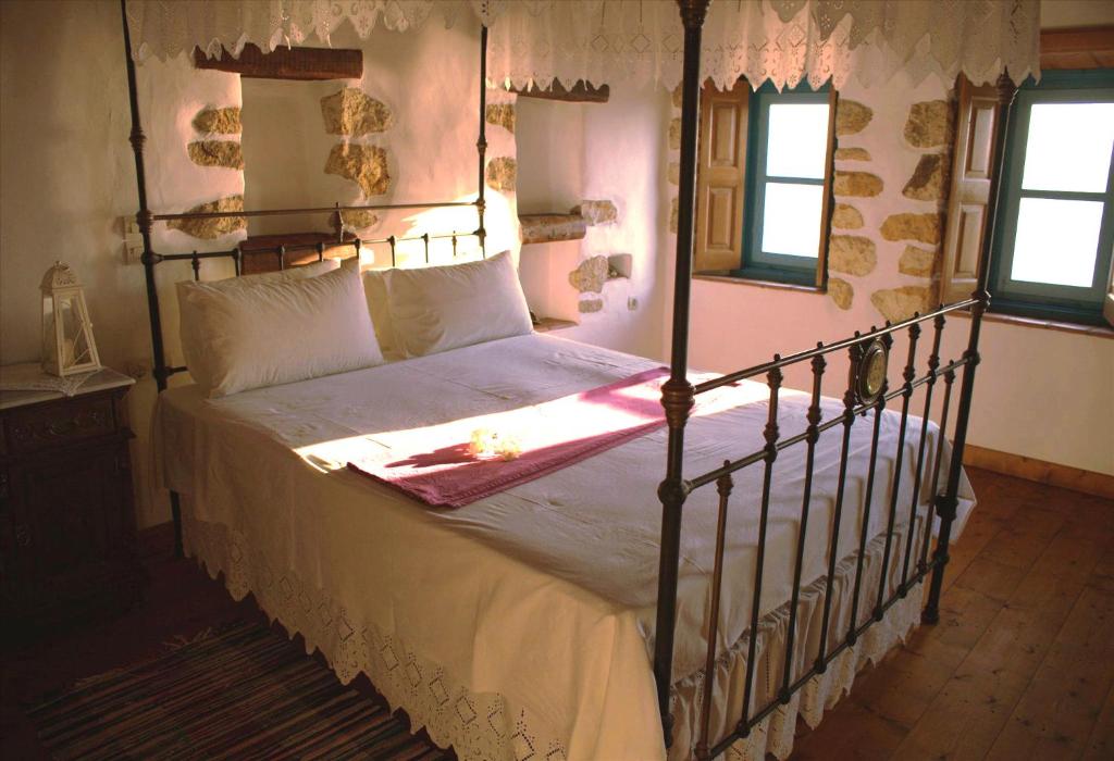 a bedroom with a bed with a metal bed frame at Eirini Luxury Hotel Villas in Grikos