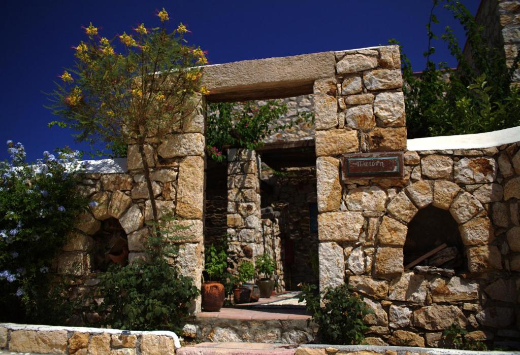 a stone wall with an entrance to a building at Eirini Luxury Hotel Villas in Grikos