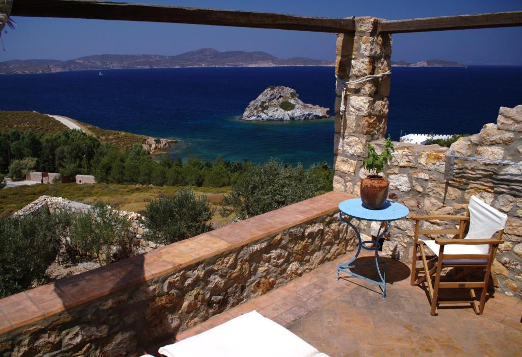 a patio with a view of the ocean and a table at Eirini Luxury Hotel Villas in Grikos