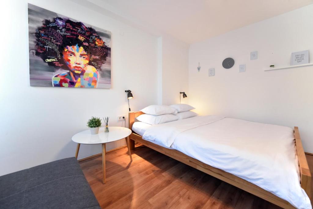 a bedroom with a bed and a table and a painting at Vla Vla Apartments, Zagreb City Center in Zagreb