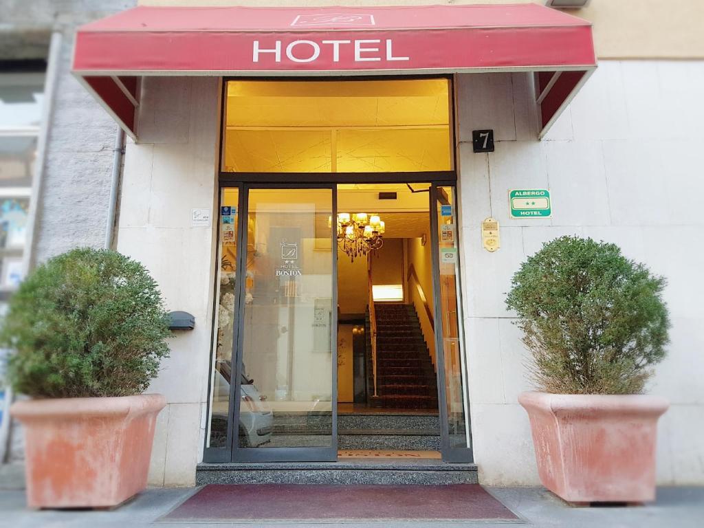 un ingresso dell'hotel con due piante in vaso davanti di Hotel Boston a Milano