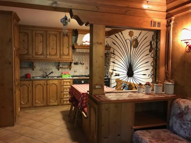 una cocina con armarios de madera y una isla en una habitación en Sweet Home, en Cortina dʼAmpezzo