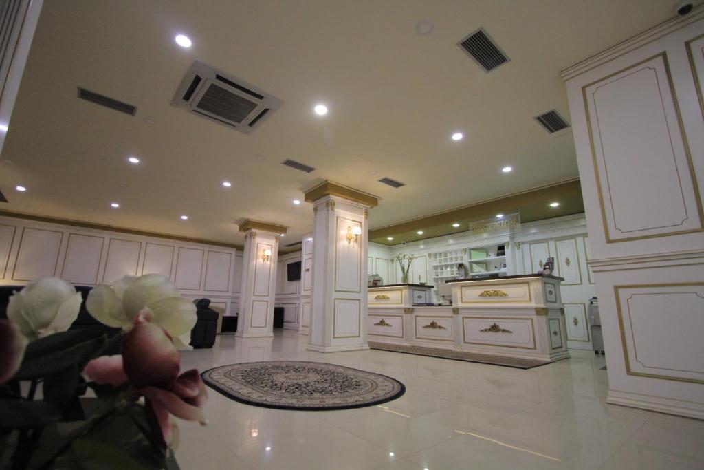 uma grande cozinha com armários brancos e um tapete em Capital Tirana Hotel Bruçi em Tirana