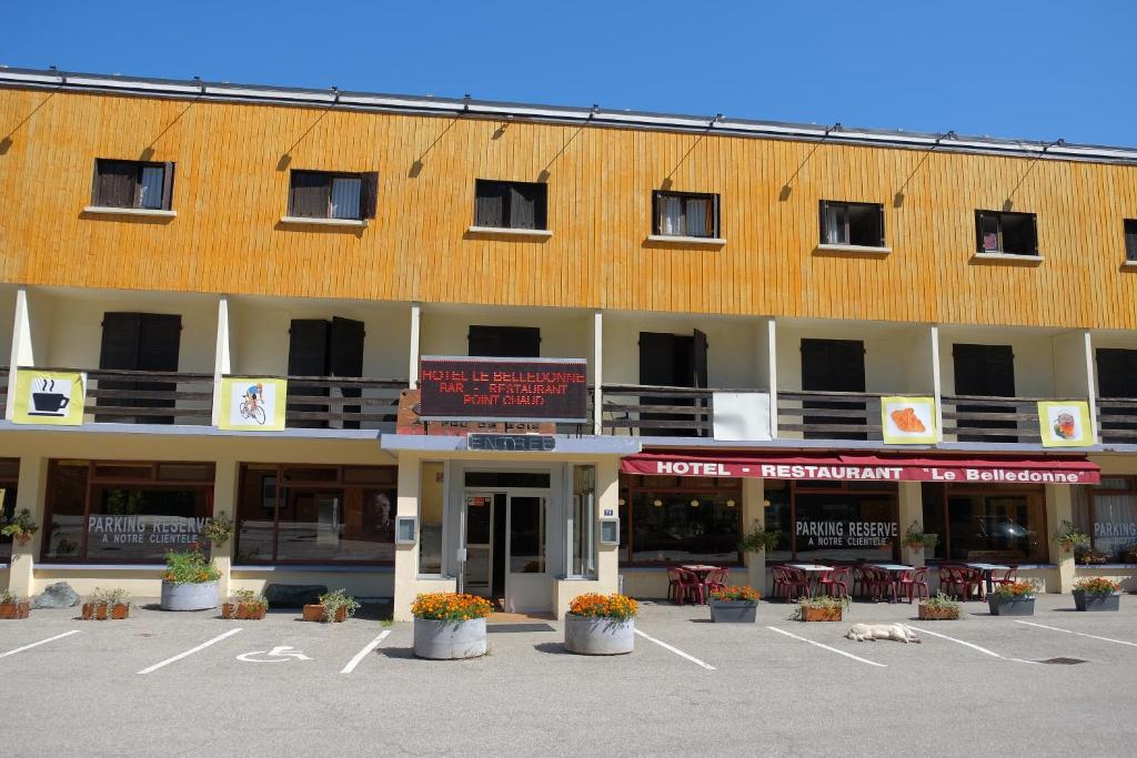 a large building with a parking lot in front of it at Hotel Belledonne in Le Bourg-dʼOisans