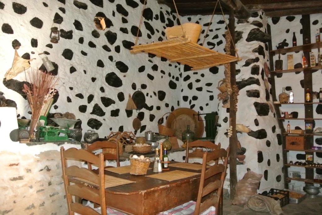 a dining room with a table and a cow print wall at Casa Princess Arminda in Betancuría