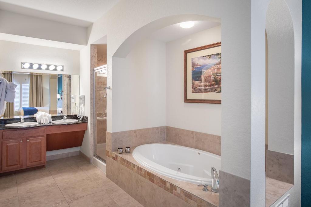 a bathroom with a tub and a sink at Lake Buena Vista Resort Village and Spa, Near Disney in Orlando