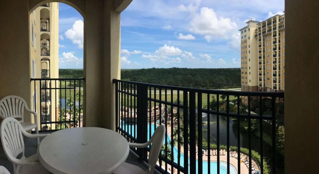 a balcony with a table and a view of a pool at Lake Buena Vista Resort Village and Spa, Near Disney in Orlando