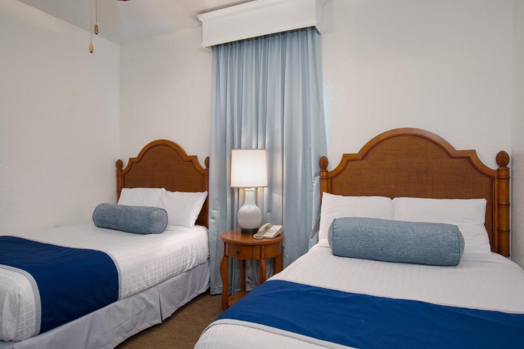 a hotel room with two beds and a table with a phone at Lake Buena Vista Resort Village and Spa, Near Disney in Orlando