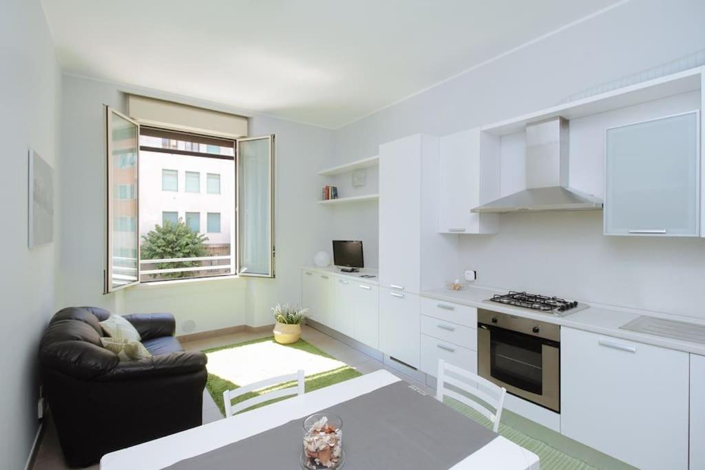 una cucina bianca con divano e tavolo di Spacious and new apt in Città Studi a Milano