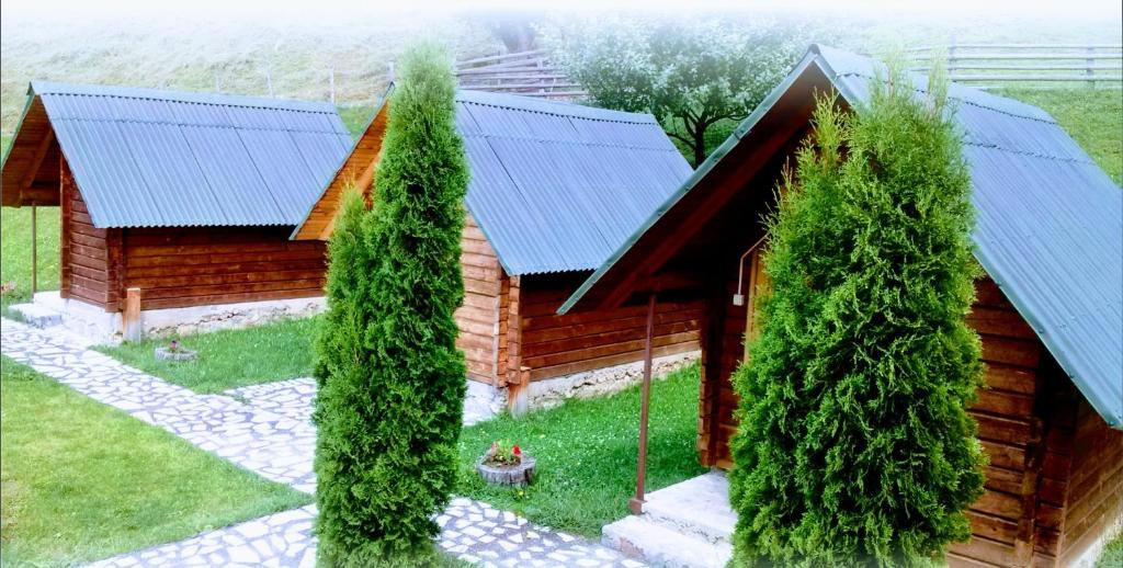 莫伊科瓦茨的住宿－Bungalovi Vukovic，前面有树木的小木屋
