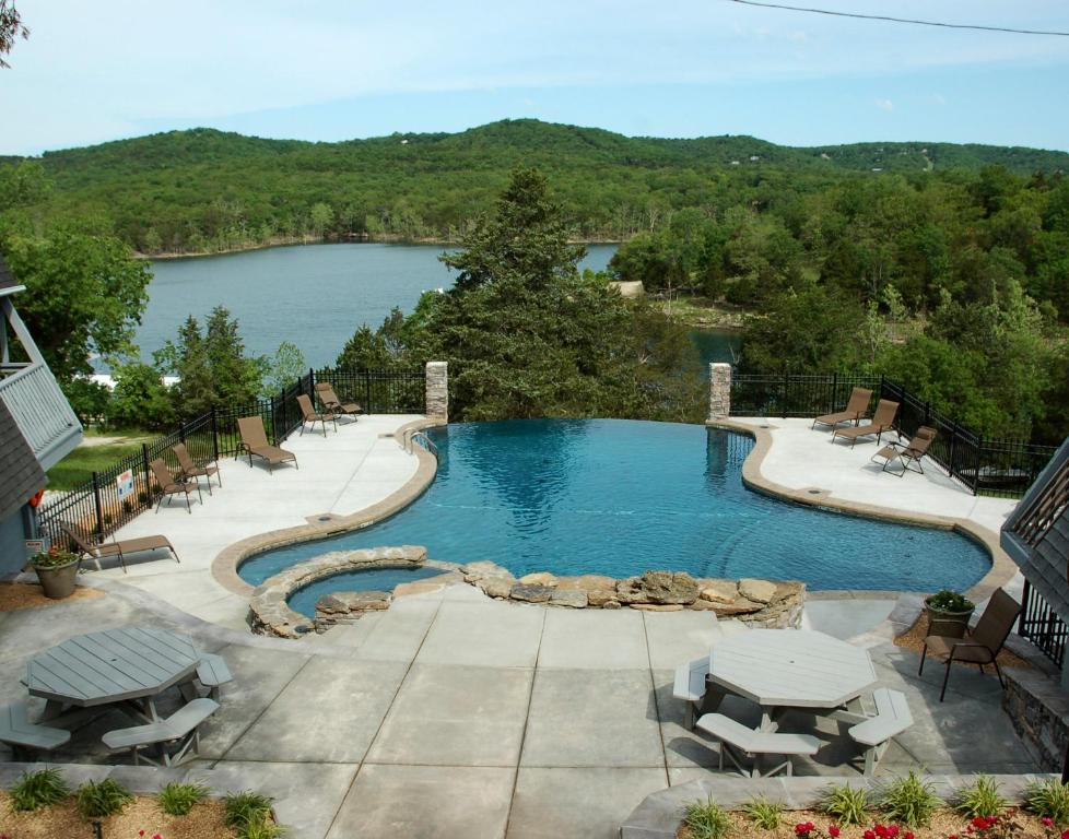 a swimming pool with a view of a lake at Alpine Lodge Resort in Branson