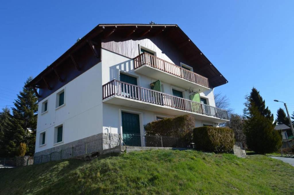 a white house with a balcony on top of a hill at Appartement RDC "Chez Marmotte" avec terrasse, 5 personnes, Font Romeu in Font-Romeu-Odeillo-Via