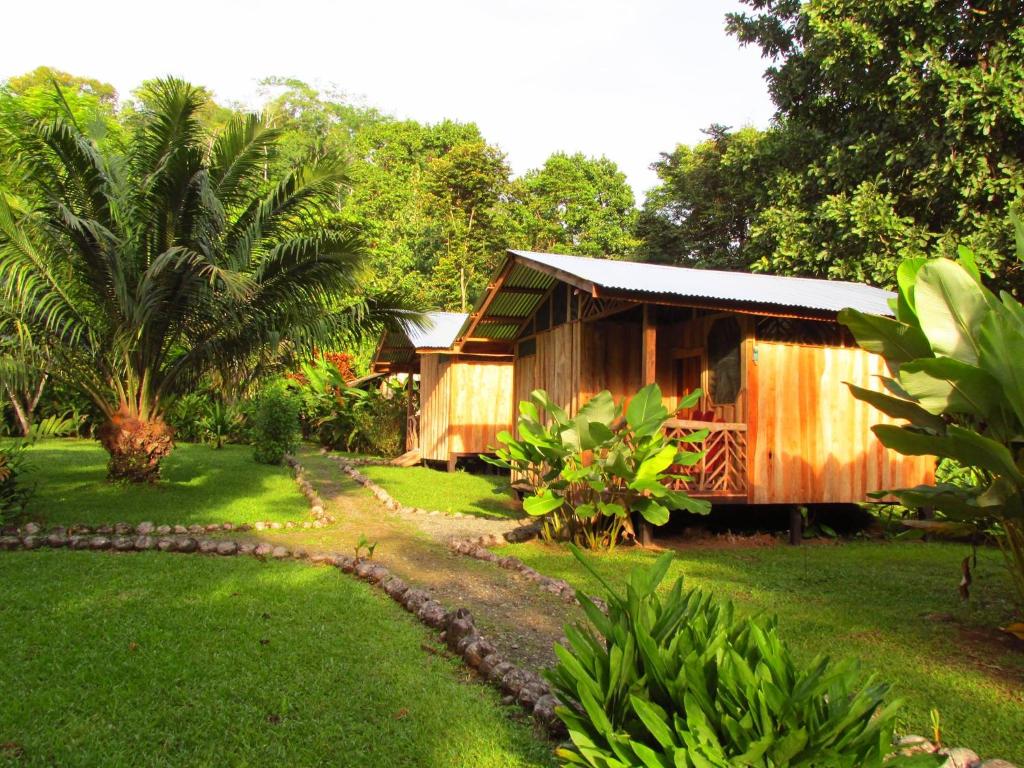 a cabin in a garden with a grass yard at El Chontal in Rincón