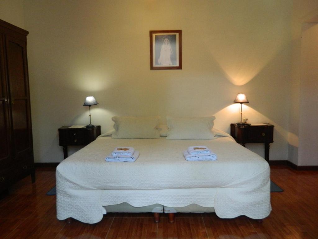 
a bed room with a white bedspread and pillows at Hostal El Cerrito San Lorenzo in San Lorenzo
