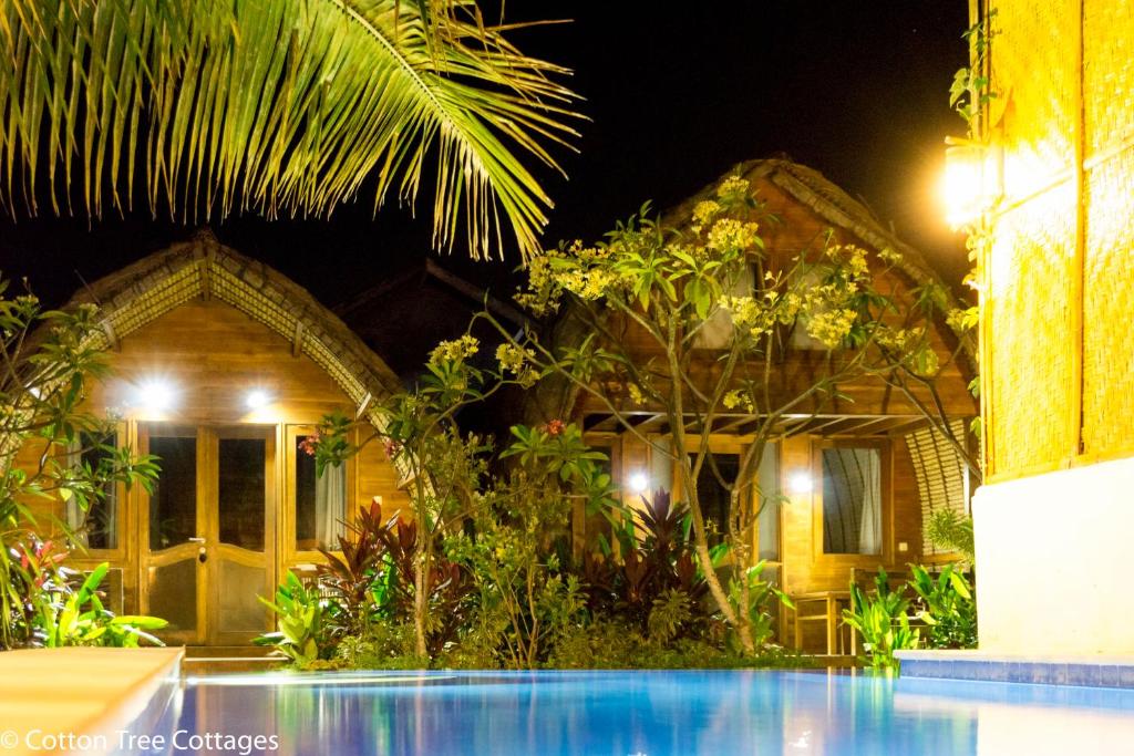 uma casa com piscina à noite em Cotton Tree Cottages em Gili Trawangan