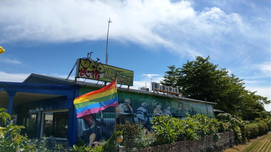 uma bandeira de arco-íris ao lado de um edifício em 鐵騎休息棧 em Fang-liao