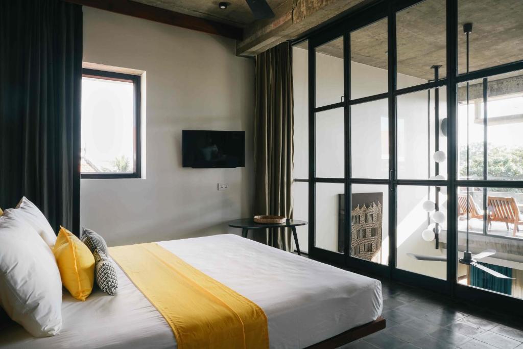 a bedroom with a bed and a large window at Urban Residences - Siem Reap in Siem Reap