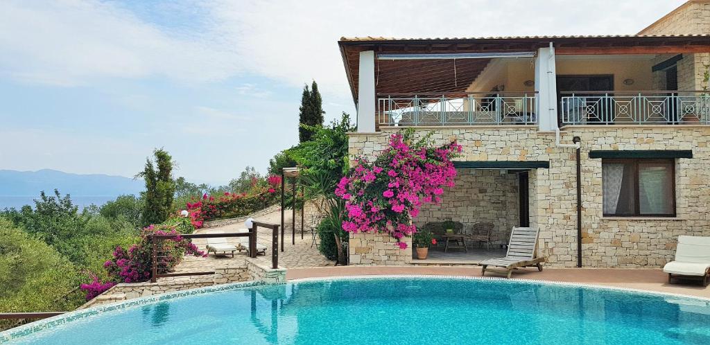 a villa with a swimming pool in front of a house at Villa Eos in Gaios