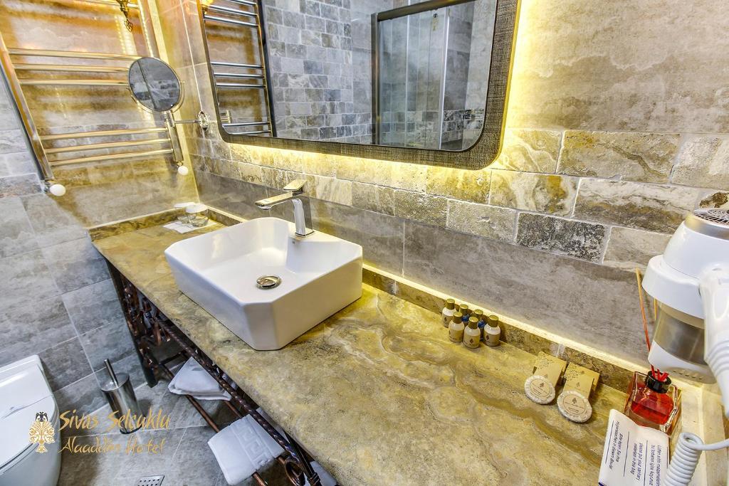 a bathroom with a sink and a mirror at Sivas Keykavus Hotel in Sivas
