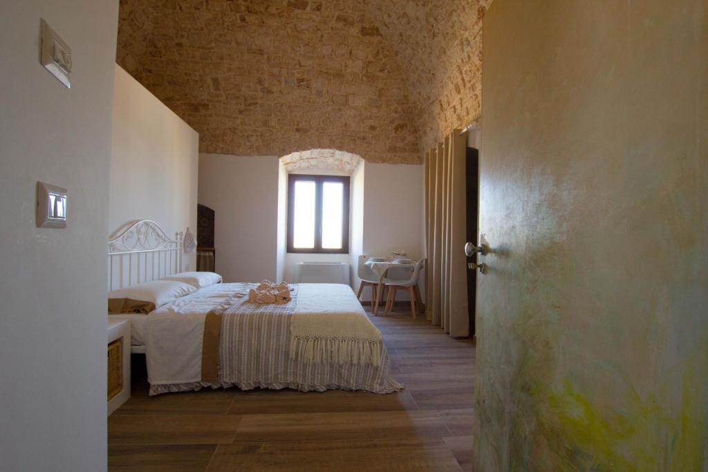 コンヴェルサーノにあるMasseria Poli Country Houseのベッドルーム1室(ベッド1台、テーブル付)