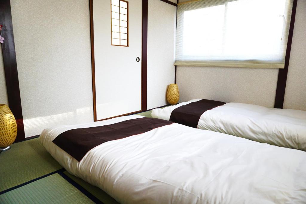 a room with two beds and a window at City Hotel Universal Studios Japan in Osaka
