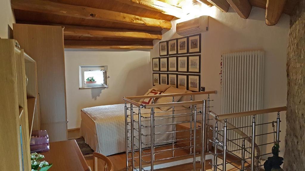 Colle Umberto的住宿－Torretta sul Colle，一间带一张床的卧室,位于带木制天花板的房间内