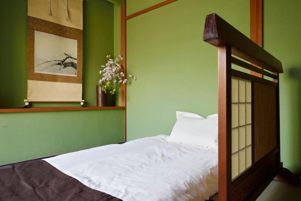 a bedroom with a white bed with a green wall at City Hotel Universal Studios Japan in Osaka