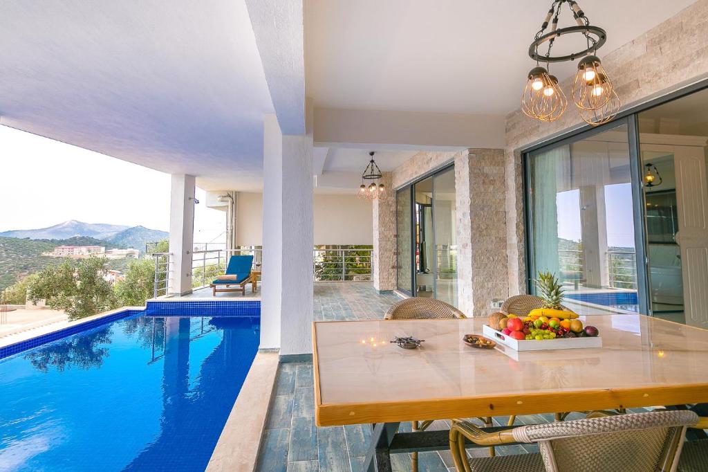 a dining room with a table and a swimming pool at Villa Spring- Hill Villas Kalkan in Kaş